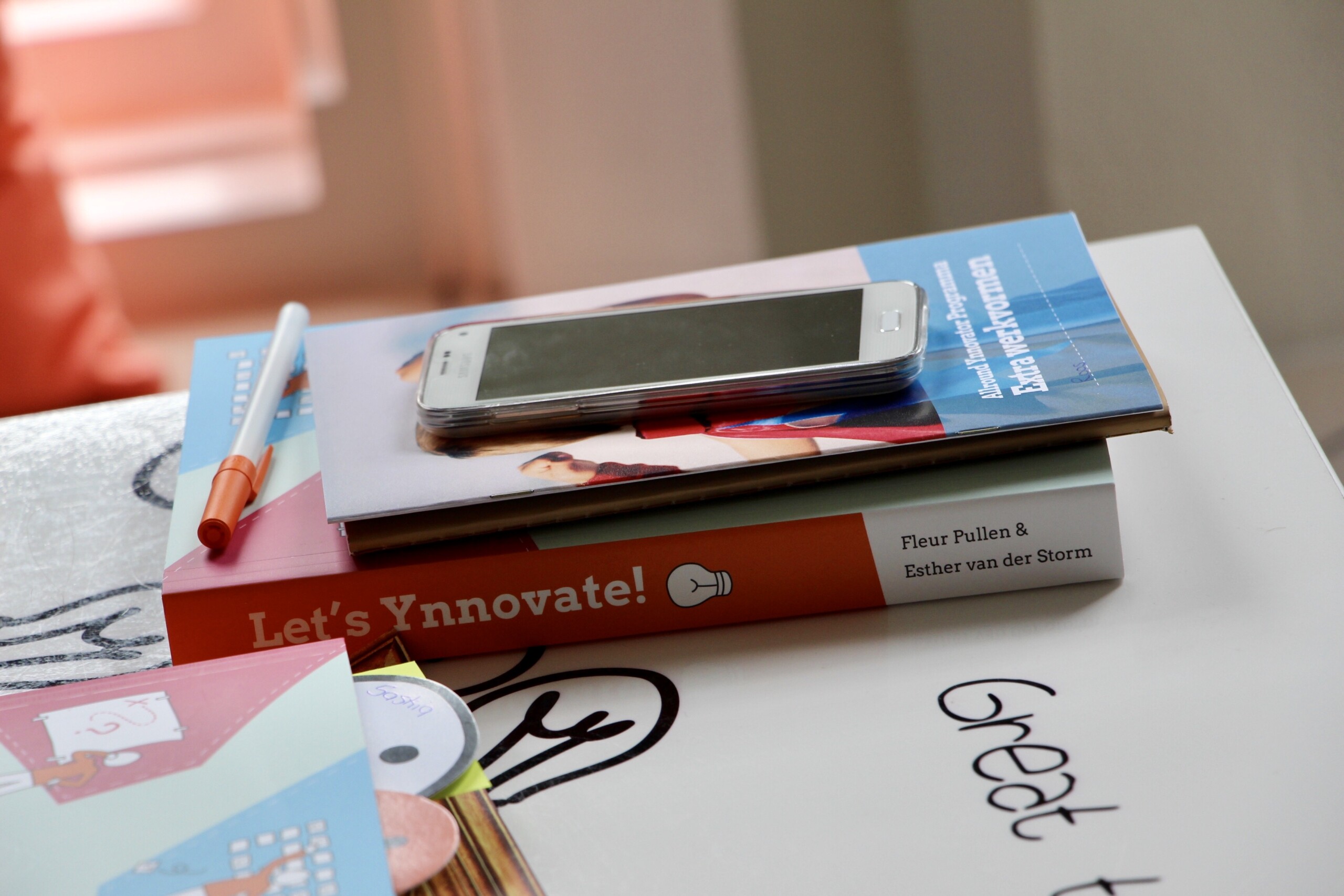 Boek Let's Ynnovate! op tafel met stift en kaarten